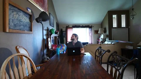 Man working at laptop in dining room Stock Footage 154761979