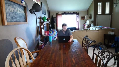 Man working at laptop in dining room Stock Footage 154762175