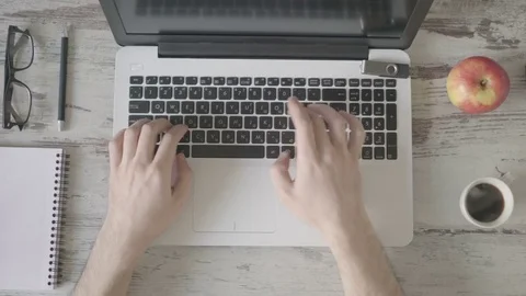 A man working on a laptop is drinking coffee. Stock Footage 80245383