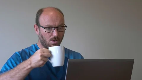 Man working on laptop drinking coffee Stock Footage 88456187