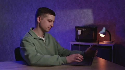 Man working on laptop during power outage using portable power station Stock Footage 334732366
