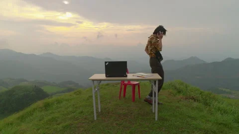 Man Working On A Laptop At A Folding Table On A Grassy Hill - Digital Nomad Stock Footage 344059982