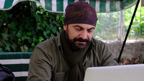 Man working with laptop in the garden looking at camera Stock Footage 145281023