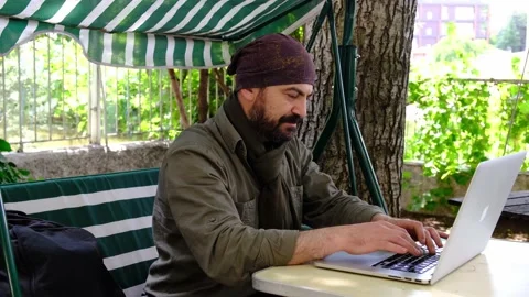 Man working with laptop in the garden looking at camera and smiling Stock Footage 145281289