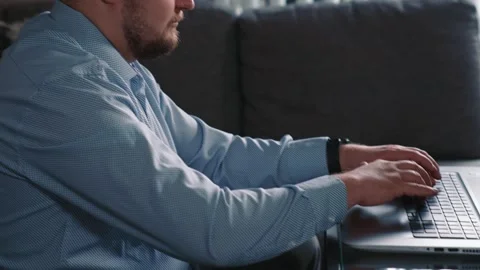 Man working on laptop at home completing online tasks Stock Footage 329944189