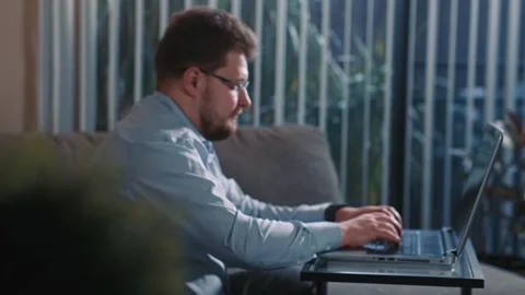 Man working on laptop at home completing online tasks Stock Footage 340206183