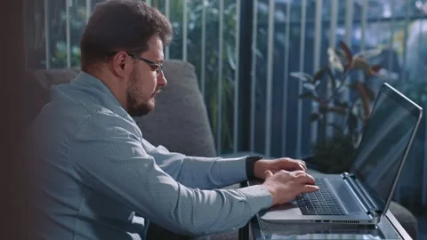Man working on laptop at home sitting near window Stock Footage 340205516