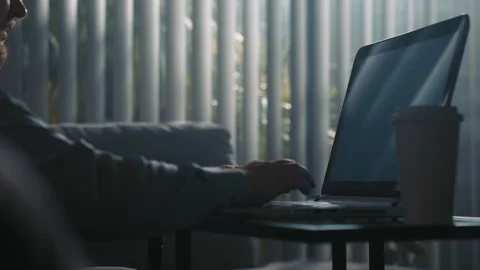 Man working on laptop at home sitting on sofa Stock Footage 340209633