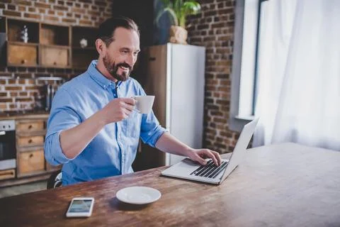 Man working on laptop at the kitchen Stock Photos
