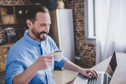Man working on laptop at the kitchen Stock Photos