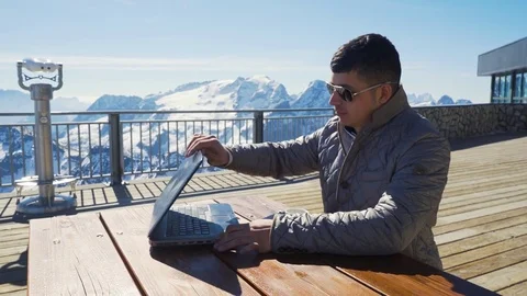 Man working on laptop with mountains on background Stock Footage 75786733