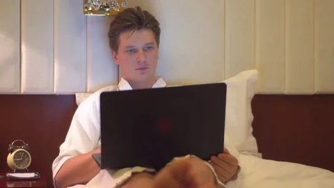 Man working on laptop at night in bed Stock Footage 72234181