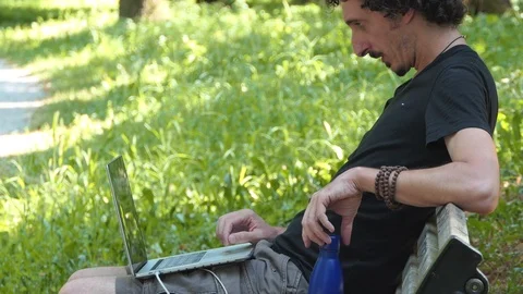 Man working at laptop in the park Video stock 114170752