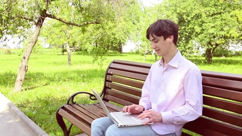 Man working with laptop in park Stock Footage 258619346