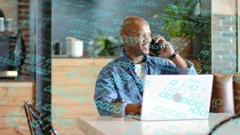 Man working laptop, phone ringing, taking call and laughing while binary overlay Stock Footage 333510300