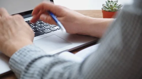 Man working on laptop placed on wooden desk Vídeo Stock 85631435
