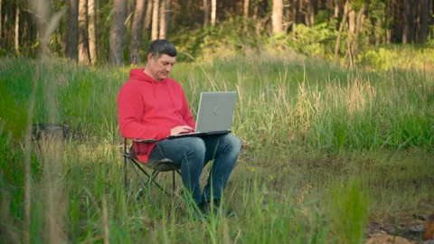 Man working on laptop in summer forest Stock Footage 154411607