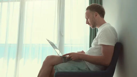 Man Working on Laptop by Sunny Window Stock Footage 279774301