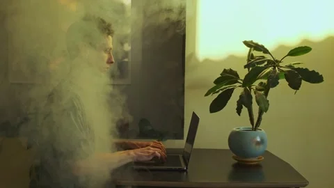 Man Working on Laptop Surrounded by Smoke, Symbolizing Work Burnout in Video stock 295930857