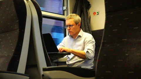 A man working on a laptop on the train Stock Footage 93681187