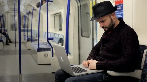 Man working with a laptop on a tube train Vídeo Stock 21024490