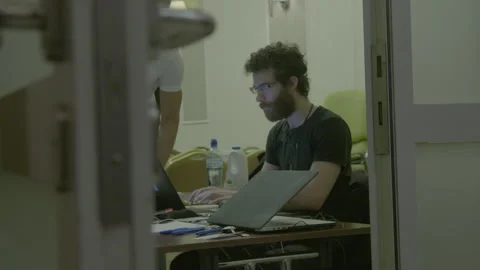 Man Working on Laptop Viewed Through Open Doorway Stock Footage 341907363