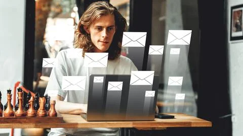 Man working on laptop while emails appear in a cafe during the day Stock Photos