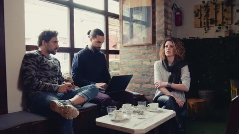 Man working on laptop while his friends are talking Stock Footage 95907462