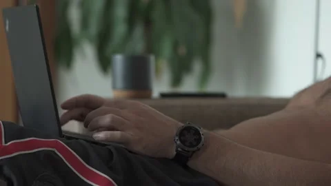 Man working on the laptop while sitting on the sofa Stock Footage 154551311