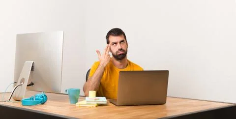Man working with laptot in a office with problems making suicide gesture Foto stock