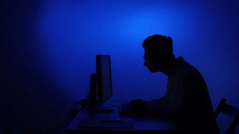 Man working late at computer with blue light Stock Footage 318980411