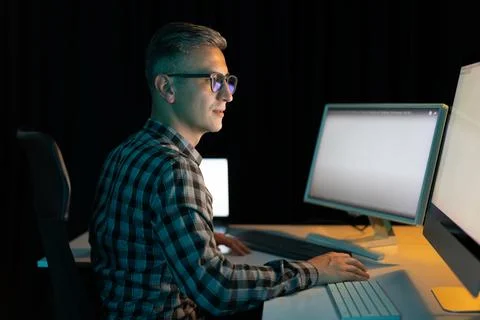Man Working Late On Computer In Dark Office Environment Foto stock