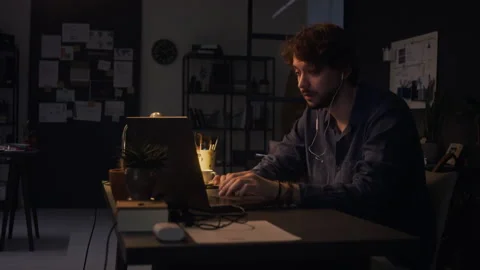 Man Working Late in Dark Office Having Online Meeting on Laptop Stock Footage 338412886