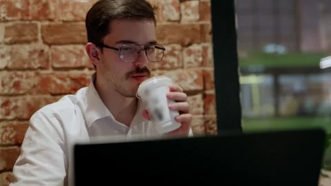 Man working late at desk with laptop and phone 库存影片 342779662
