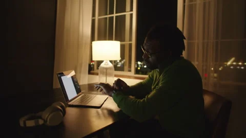 Man working late at night on laptop with smartwatch and lamp on desk Stock Footage 312582798