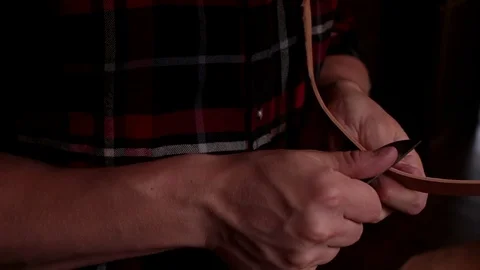 Man working with leather, edging with a knife Stock Footage 91747421