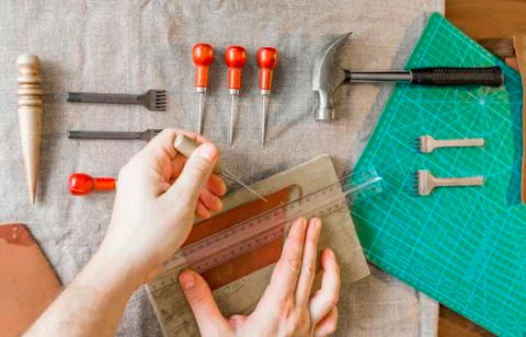 Man working with leather using crafting DIY tools Stock Photos