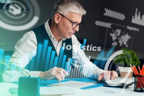 Man working on logistics tasks and analyzing data in an office setting during Stock Photos