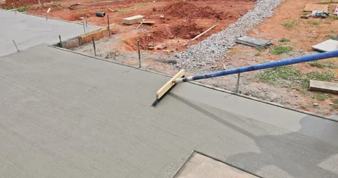 Man working with long tool to finish concrete surface at construction site Stock Footage 342658767