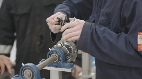 A man is working on a machine with a blue and silver part Stock Footage 301626698