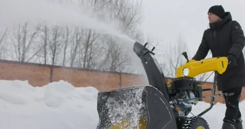 Man working with manual snow blower. Snowy winter. Man removes snow snowdrifts Stock Footage 169728150