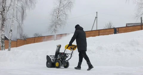 Man working with manual snow blower. Snowy winter. Man removes snow snowdrifts Stock Footage 171389997
