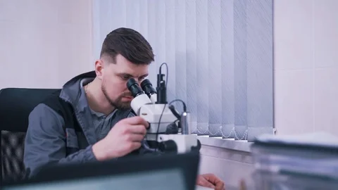 Man working with a microscope in a lab Stock Footage 112152913