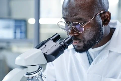 Man working with microscope at the lab Stock Photos