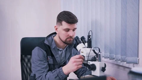 Man working with a microscope in a laboratory Stock Footage 112152889