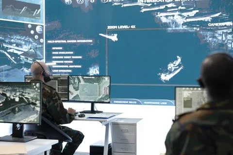 Man working in military command center filled with surveillance displays Stock Photos