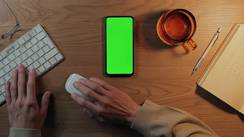 Man working on mobile with green screen and keyboard Stock Footage 164035511