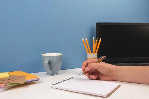 Man working on modern creative enterpreneur workspace. Blue cup of coffee Stock Photos