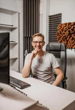 Man working in music studio using computer wearing glasses. Sound engineer wo Foto stock