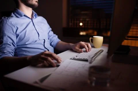 Man working at night, using computer Foto stock